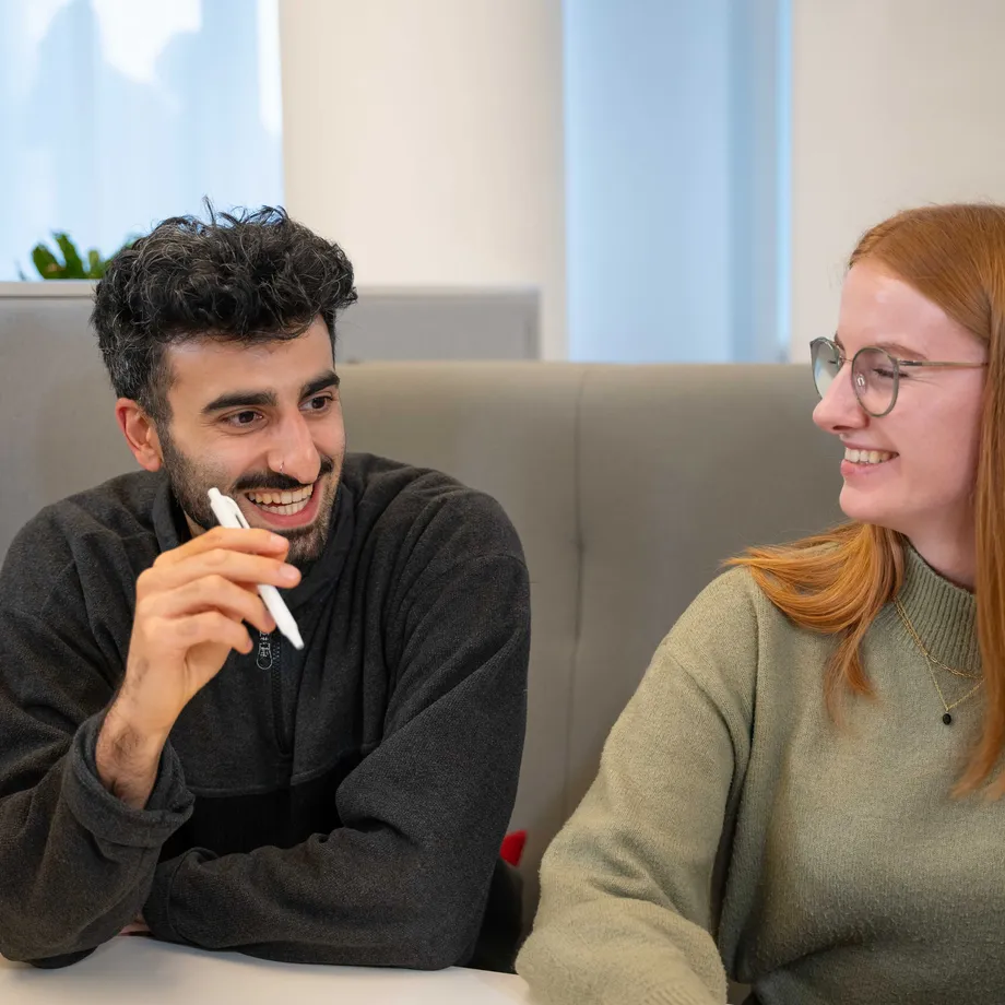 Mehrere Personen sitzen gemeinsam in einer Lounge und unterhalten sich.